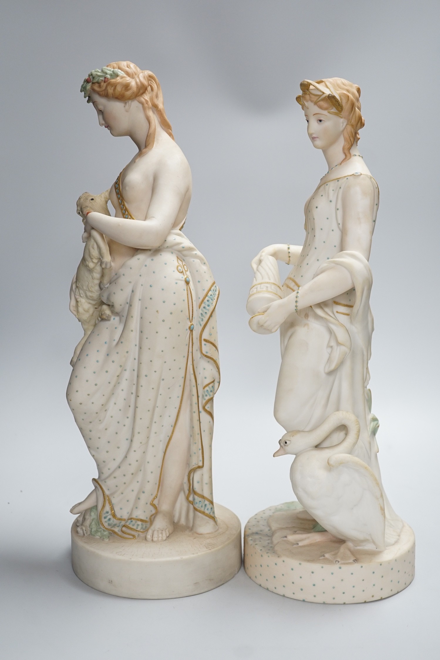 A pair of large W H Goss bisque classical female figures, one with lamb, the other Leda and the Swan, 45cm